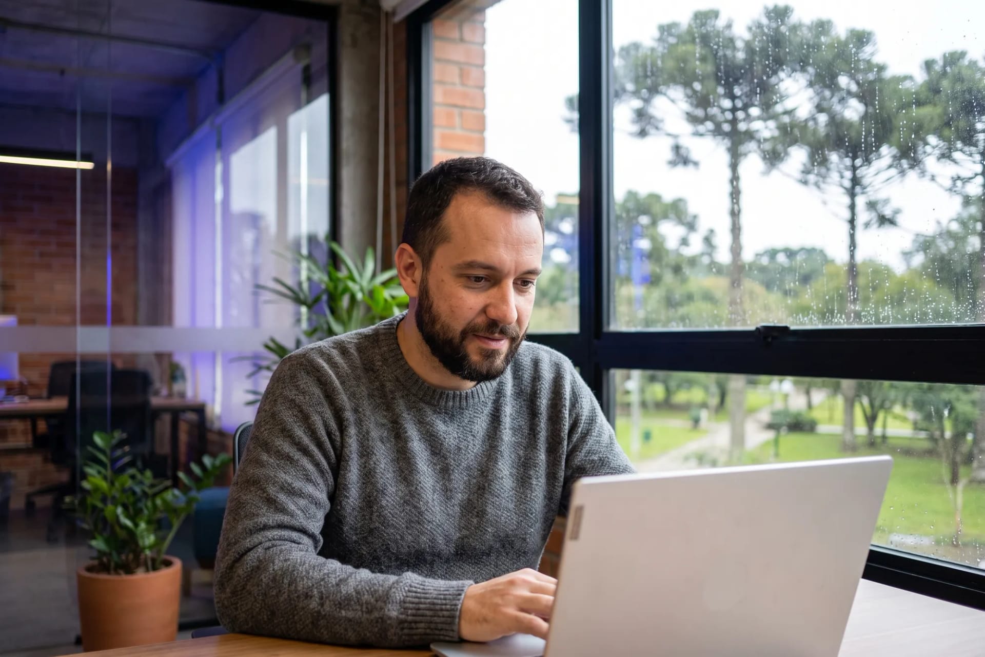 Empreendedor trabalhando em um escritório arborizado em Curitiba