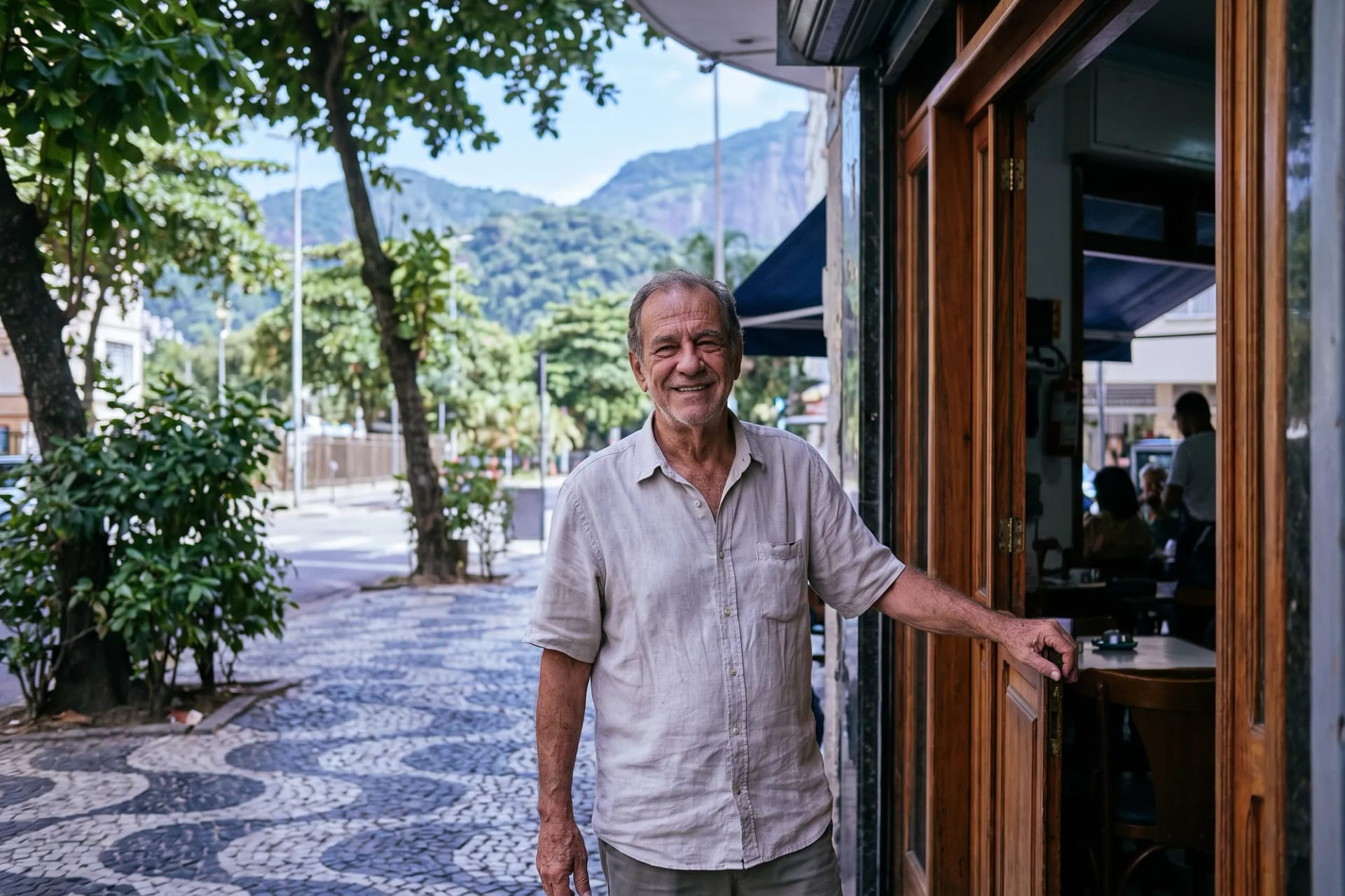 Dono de um café em uma rua arborizada do Rio de Janeiro