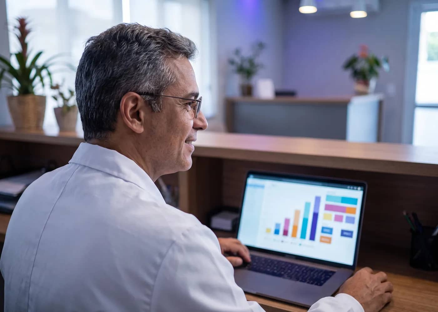 Dentista conferindo gráficos de desempenho de campanhas no notebook da clínica