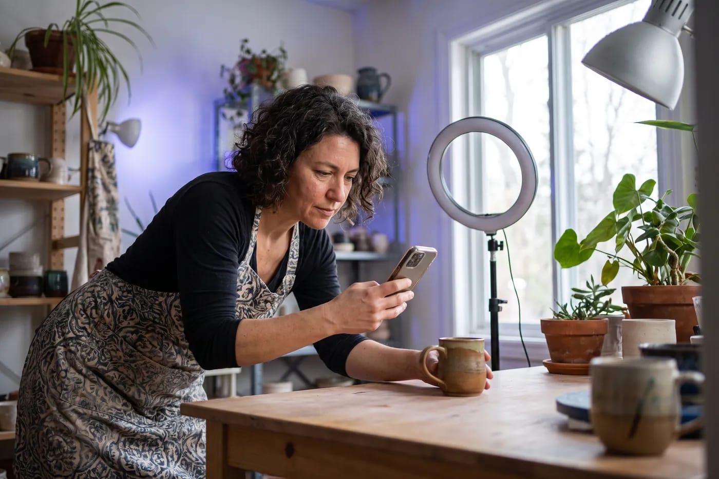 Empreendedora fotografando um produto com o celular para as redes sociais