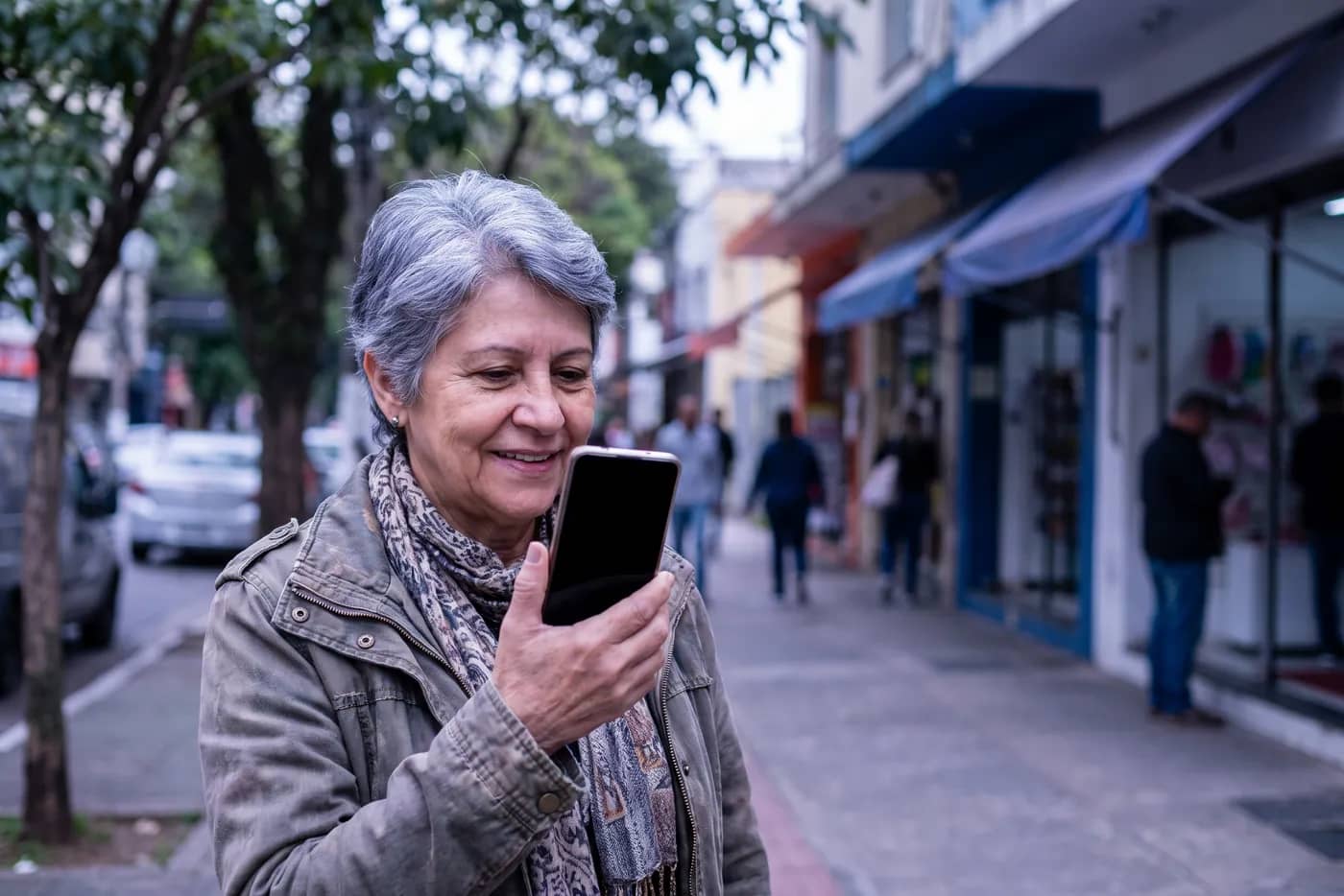 Pessoa pesquisando um serviço no celular na rua de um bairro